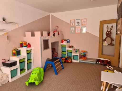 Spielzimmer mit Spielzeug, Klettergerüst und einem Spielhaus in sanften Farben.